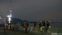 Para pemudik nampak tengah bersantai sambil menunggu naik ke kapal dengan menikmati senja. 