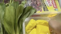 Sedikit makanan sehat dan segar ada di kulkas Fuji. Terlihat ada stok tahu kuning dan sawi hijau.