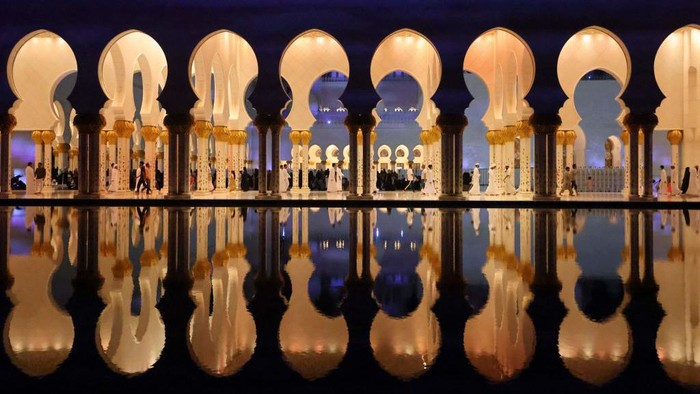 TOPSHOT - Believers walk through the courtyard of the Sheikh Zayed Grand Mosque in Abu Dhabi late on April 17, 2023 on Laylat al-Qadr, one of the holiest nights during the Muslim holy fasting month of Ramadan. - Laylat al-Qadr (Night of Destiny) marks the night Muslims believe the first verses of the Koran were revealed to Prophet Muhammad by the angel Gabriel in the seventh century. (Photo by Karim SAHIB / AFP) (Photo by KARIM SAHIB/AFP via Getty Images)