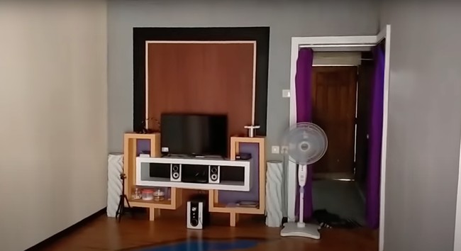 Tak seperti penampakan luarnya, bagian dalam rumah justru tampak cukup rapih. Bahkan barang-barang elektroniknya pun terlihat lumayan lengkap, seperti televisi, speaker, dan kipas angin. Foto: YouTube/Abiza TV