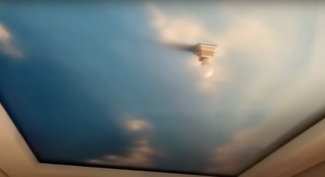 Uniknya langit-langit rumah ini dibuat seperti layaknya langit biru lengkap dengan awan putihnya. Bukan menggunakan wallpaper, dalam video juga diperlihatkan proses pembuatan gambar di langit-langit rumah secara manual menggunakan tangan. Foto: YouTube/Abiza TV