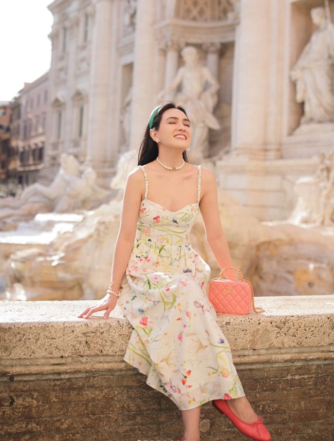 Tampil lebih feminin dan simpel, Shandy Aulia memilih mengenakan dress panjang motif bunga tanpa lengan. Penampilannya itu kemudian dilengkapi dengan anting, gelang, dan kalung mutiara, bando hijau, serta tas dan sepatu berwarna peach. Foto: Instagram/@shandyalia