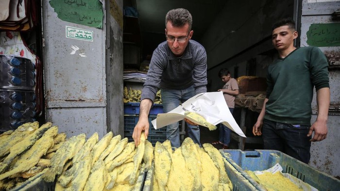 Berburu Ikan Asin di Pasar Gaza untuk Sajian Lebaran A Palestinian vendor sells salted fish called (Feseekh) at a market in Gaza City, on April 19, 2023 ahead of Eid al-Fitr which marks the end of the Muslim Holy month of Ramadan.
(Photo by Majdi Fathi/NurPhoto via Getty Images)