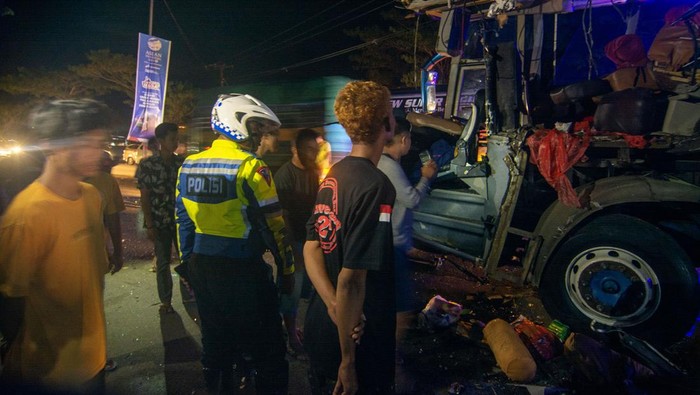 KECELAKAAN BUS ANGKUTAN MUDIK DI TRANS SULAWESI Sejumlah warga dan polisi menyaksikan bus Bintang Prima yang ringsek setelah menabrak kendaraan pengangkut kontainer yang sedang parkir di ruas jalan Trans Sulawesi, Kota Pare-Pare, Sulawesi Selatan, Kamis (20/4/2023) dini hari. Tidak ada korban jiwa dalam kecelakaan tersebut, tapi sejumlah pemudik rute Makassar-Masamba itu mengalami luka-luka dan dilarikan ke rumah sakit setempat. ANTARA FOTO/Basri Marzuki/aww.