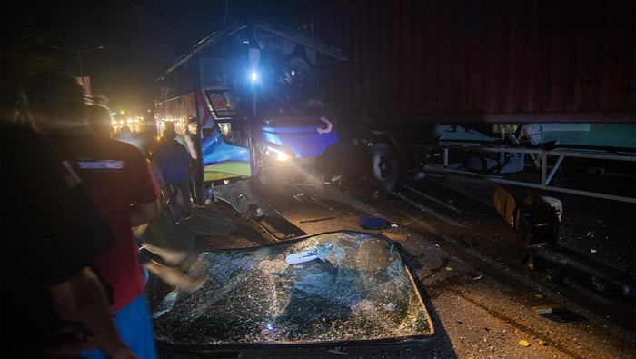 KECELAKAAN BUS ANGKUTAN MUDIK DI TRANS SULAWESI Sejumlah warga dan polisi menyaksikan bus Bintang Prima yang ringsek setelah menabrak kendaraan pengangkut kontainer yang sedang parkir di ruas jalan Trans Sulawesi, Kota Pare-Pare, Sulawesi Selatan, Kamis (20/4/2023) dini hari. Tidak ada korban jiwa dalam kecelakaan tersebut, tapi sejumlah pemudik rute Makassar-Masamba itu mengalami luka-luka dan dilarikan ke rumah sakit setempat. ANTARA FOTO/Basri Marzuki/aww.