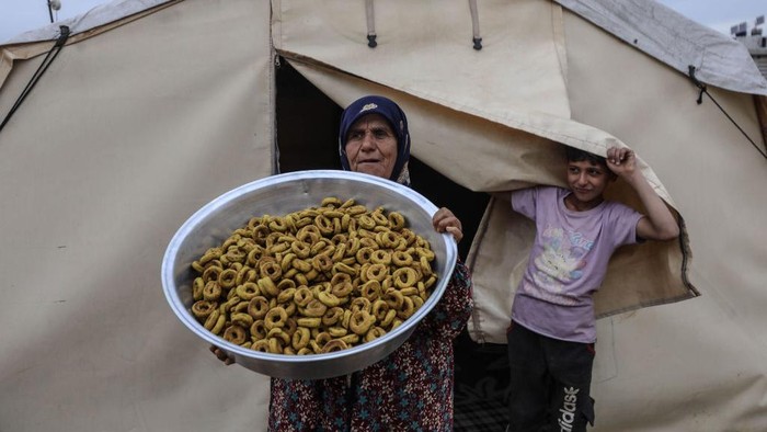 Melestarikan Kue Asin Menjelang Lebaran dari Tenda Pengungsian di Suriah IDLIB, SYRIA - APRIL 19: Displaced women, living at tent city, prepare salty cookie to make salty cookie tradition alive ahead of upcoming Eid Al-Fitr holiday in Idlib, Syria on April 19, 2023. People, fleeing their homes due to the attacks, take shelter in the tent camps of Idlib. (Photo by Izzeddin Kasim/Anadolu Agency via Getty Images)