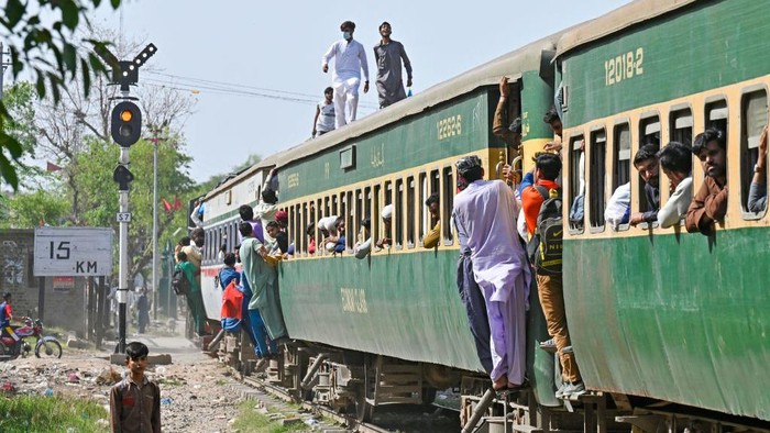 Padatnya Kereta Api di Pakistan Jelang Lebaran Passengers board a train at a railway station in Lahore on April 20, 2023, as they travel back home ahead of Eid al-Fitr festival marking the end of the holy fasting month of Ramadan. (Photo by Arif Ali / AFP) (Photo by ARIF ALI/AFP via Getty Images)