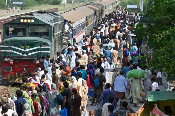 Passengers board a train at a railway station in Lahore on April 20, 2023, as they travel back home ahead of Eid al-Fitr festival marking the end of the holy fasting month of Ramadan. (Photo by Arif Ali / AFP) (Photo by ARIF ALI/AFP via Getty Images)