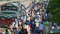 Penumpang berbondong-bondong naik kereta api di stasiun kereta api di Lahore, Pakistan, Kamis (20/4/2023).