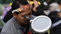 Selain kacamata khusus, sebagian warga melihat gerhana menggunakan teleskop.