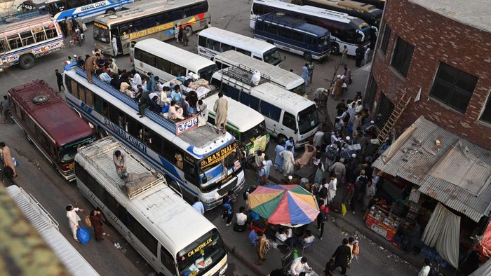 People throng a bus station in Lahore on April 19, 2023, as people head towards their hometowns for the Eid al-Fitr festivities, which marks the end of the holy fasting month of Ramadan. (Photo by Arif Ali / AFP) (Photo by ARIF ALI/AFP via Getty Images)