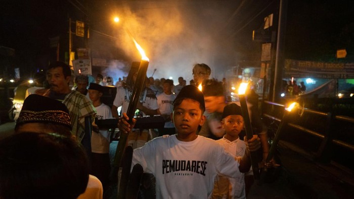 Sejumlah anak-anak mengikuti takbir keliling dengan membawa obor bambu di Minggir, Sleman, D.I Yogyakarta, Kamis (20/4/2023). Takbir keliling yang diikuti oleh ratusan perserta dengan berjalan berkeliling kampung ke kampung tersebut untuk menyambut malam hari raya Idul Fitri 1444 H. ANTARA FOTO/Andreas Fitri Atmoko/YU