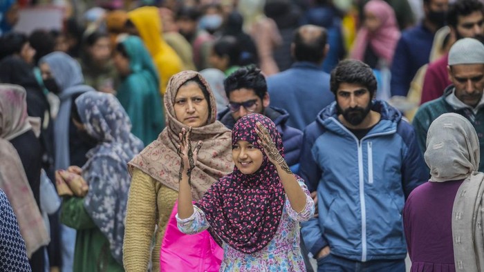 A Kashmiri Muslim girl, hands decorated with henna walks among the crowd ahead of Eid al-Fitr in Srinagar, Indian controlled Kashmir, Tuesday, April 18, 2023. Eid al-Fitr, marks the end of the fasting month of Ramadan. (AP Photo/Mukhtar Khan)