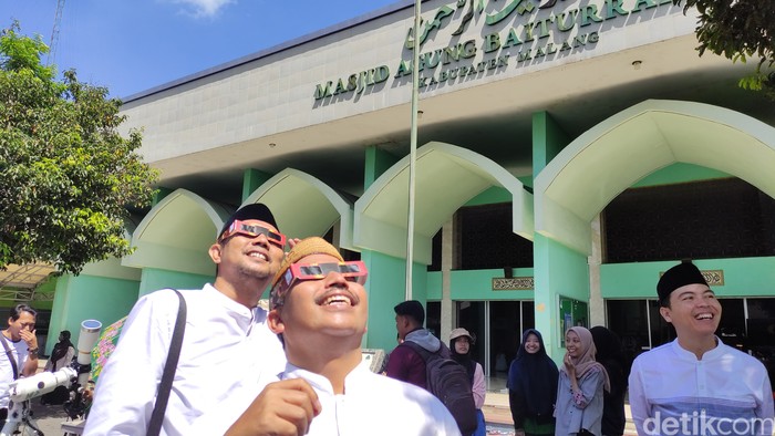 warga melihat gerhana matahari hibrida di halaman masjid Baiturrahman Kepanjen