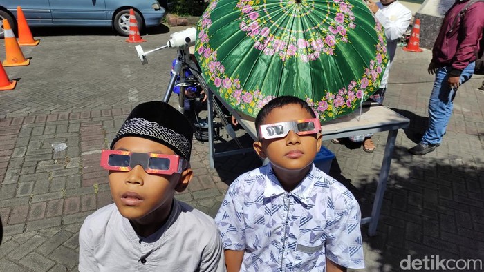 warga melihat gerhana matahari hibrida di halaman masjid Baiturrahman Kepanjen