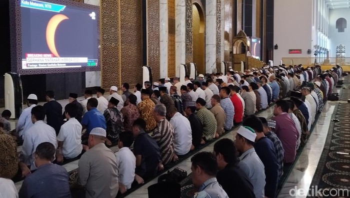 warga melihat gerhana matahari hibrida lewat layar di surabaya
