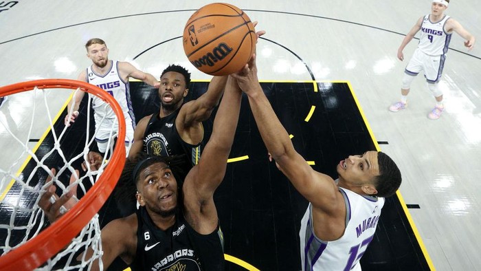 SAN FRANCISCO, CALIFORNIA - APRIL 20: Kevon Looney #5 and Andrew Wiggins #22 of the Golden State Warriors go for rebound against Keegan Murray #13 of the Sacramento Kings during Game Three of the Western Conference First Round Playoffs at Chase Center on April 20, 2023 in San Francisco, California. NOTE TO USER: User expressly acknowledges and agrees that, by downloading and or using this photograph, User is consenting to the terms and conditions of the Getty Images License Agreement. (Photo by Ezra Shaw/Getty Images)