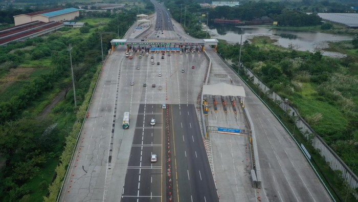 Foto udara sejumlah kendaraan melewati Gerbang Tol Cikampek Utama di Karawang, Jawa Barat, Jumat (21/4/2023). Sehari menjelang Hari Raya Idul Fitri lalu lintas kendaraan di ruas Tol Jakarta-Cikampek tampak lancar cenderung lengang dari pagi hingga sore hari. ANTARA FOTO/Aditya Pradana Putra/YU
