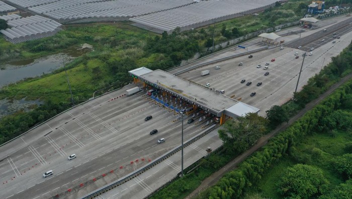 Foto udara sejumlah kendaraan melewati Gerbang Tol Cikampek Utama di Karawang, Jawa Barat, Jumat (21/4/2023). Sehari menjelang Hari Raya Idul Fitri lalu lintas kendaraan di ruas Tol Jakarta-Cikampek tampak lancar cenderung lengang dari pagi hingga sore hari. ANTARA FOTO/Aditya Pradana Putra/YU