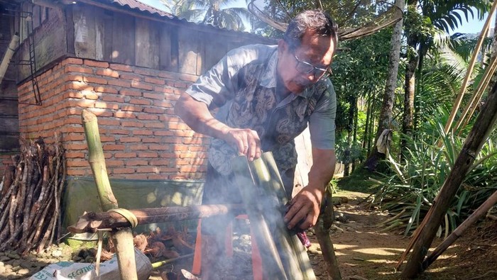 Membuat lemang Salah seorang warga di Kabupaten Madina saat mangalomang. Foto: Finta Rahyuni/detikSumut