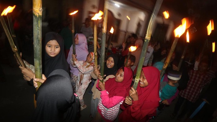Sejumlah anak membawa obor saat takbir keliling di Kelurahan Ngronggo, Kota Kediri, Jawa Timur, Jumat (21/4/2023). Takbir keliling mengitari kampung setempat tersebut guna menyambut datangnya Idul Fitri 1444 H. ANTARA FOTO/Prasetia Fauzani/YU