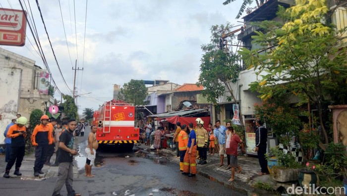 Petugas PMK Surabaya saat pembasahan ruko di Surabaya yang terbakar