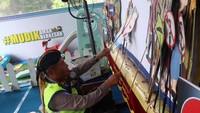 Anggota Satlantas Polres Jombang menampilkan wayang lalu lintas (Wakultas) di pos pelayanan lebaran Polres Jombang di SPBU Bandar Kedungmulyo, Kabupaten Jombang, Jawa Timur, Jumat (21/4/2023).
