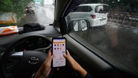 Pemudik sedang menggunakan aplikasi BTN Mobile saat terjebak macet di ruas jalan tol Jakarta-Cikampek, Kamis (20/4). 