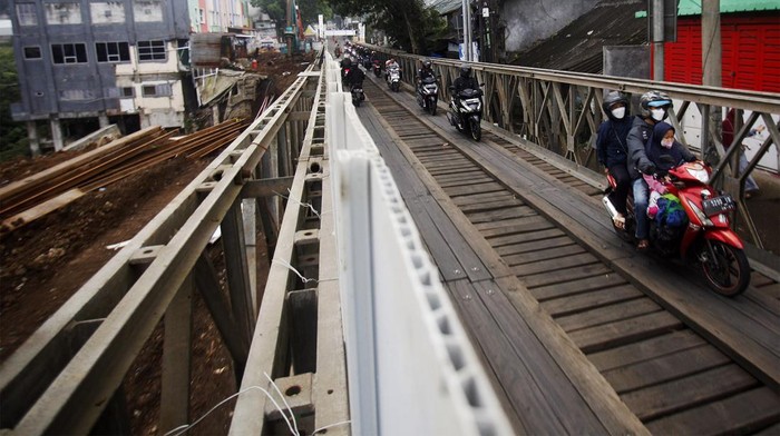 Uji Nyali, Mudik Lewat Jembatan Darurat Cikreteg Sejumlah pemudik motor melintasi jembatan darurat di jalan raya utama Bogor-Sukabumi, Cikreteg, Kabupaten Bogor, Jawa Barat, Jumat (21/4/2023). Akses utama jalur Bogor-Sukabumi melalui Jembatan Cikereteg masih diperbaiki hingga saat ini, sehingga jembatan tersebut hanya bisa dilalui oleh sepeda motor. ANTARA FOTO/Yulius Satria Wijaya/rwa.