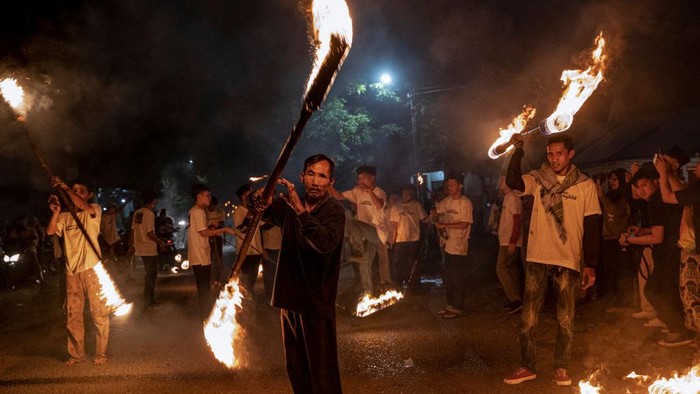 Atraksi Api Semarakkan Idul Fitri YOGYAKARTA, INDONESIA - APRIL 21: Indonesian Muslim men spit fire during a parade as Muslims celebrate Eid Al-Fitr to mark the end of the holy month of Ramadan on April 21, 2023 in Yogyakarta, Indonesia. Muslims around the world celebrate Eid al-Fitr with their families with feasts to mark the end of Ramadan, the holy month of fasting. (Photo by Ulet Ifansasti/Getty Images)
