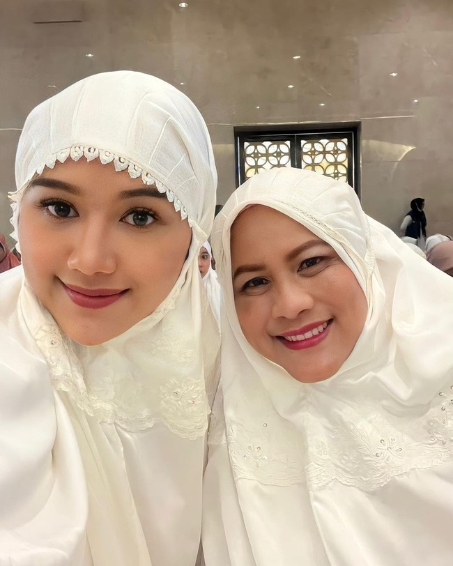 Erina dan Irina tampak kompak berbalut mukena putih sampai-sampai dipuji seperti kembaran oleh netizen. “Bu Negara mirip banget sama mantunya. Eh salah Mbak Erina mirip sama Bu Iriana. Namanya juga hampir sama,” tulis seorang pengguna Instagram. Ada pula yang berkomentar, “Masyaallah mbk erina mirip ibu mertua bu iriana.” (Foto: Instagram/@erinagudono)