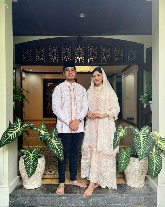 Erina juga menyertakan foto berdua dengan sang suami. Sebuah gaun berlapis bordiran yang feminin bernuansa pink dengan detail beading dipadu kerudung panjang menjadi andalan finalis Puteri Indonesia 2022 itu. (Foto: Instagram/@erinagudono)