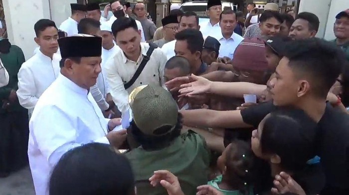 Ketua Umum Partai Gerindra Prabowo Subianto ditemani Wali Kota Solo Gibran Rakabuming Raka membagikan amplop kepada warga usai bertemu Habib Syech di Solo, Sabtu (22/4/2023) .