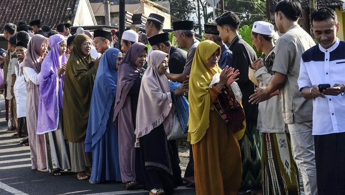 Salaman, Tradisi Saling Memaafkan Saat Lebaran Foto udara warga berjabat tangan usai melaksanakan Shalat Idul Fitri di Desa Darmaraja, Kabupaten Ciamis, Jawa Barat, Sabtu (22/4/2023). Tradisi bersalaman massal Lebaran antardusun tersebut dilaksanakan pada perayaan Idul Fitri 1444 H dengan tujuan untuk saling memaafkan dan menjaga tali silahturahim serta memperkokoh kerukunan antarumat beragama. ANTARA FOTO/Adeng Bustomi/nym.