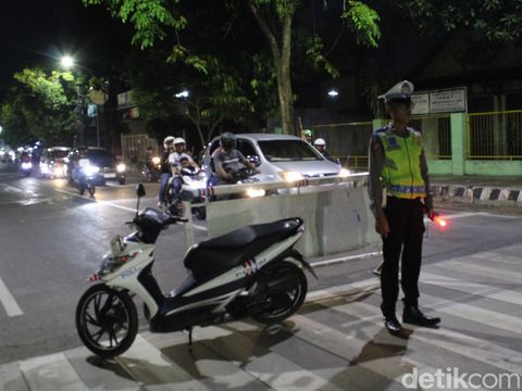 Seorang anggota polisi mengadang kendaraan yang melakukan konvoi takbir keliling di kota Blora, Jawa Tengah, Jumat (24/1/2023) malam.