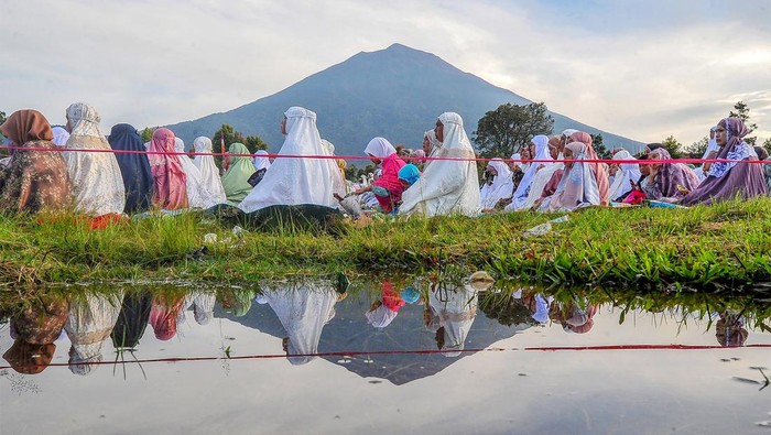 Umat Islam bersiap menunaikan Shalat Idul Fitri di lapangan Gunung Labu dengan latar belakang Gunung Kerinci, Jambi, Sabtu (22/4/2023). Pelaksanaan Shalat Idul FItri 1444 Hijriah di daerah itu diikuti ratusan warga muslim. ANTARA FOTO/Wahdi Septiawan/nym.