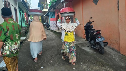 Warga Desa Pegayamanan melaksanakan tradisi ngejot dengan mengantarkan makanan ke rumah tetangga, sanak saudara, hingga sesepuh, pada Jumat (21/3/2023). (Made Wijaya Kusuma/detikBali)