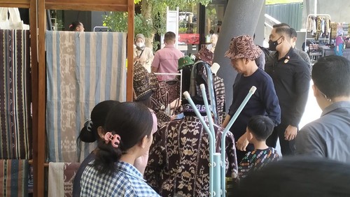 Presiden Jokowi membeli kain tenun NTT dan topi pantai setelah berkunjung ke Goa Batu Cermin, Minggu (23/4/2023).