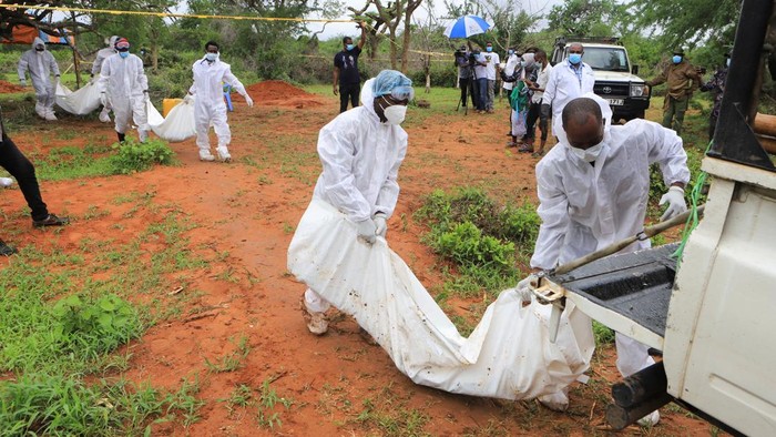 Forensic experts and homicide detectives carry the bodies of suspected members of a Christian cult named as Good News International Church, who believed they would go to heaven if they starved themselves to death, after their remains were exhumed from their graves in Shakahola forest of Kilifi county, Kenya, April 22, 2023. REUTERS/Stringer
