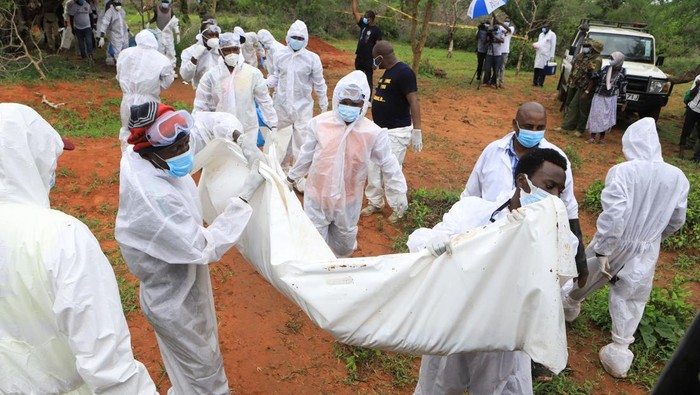 Forensic experts and homicide detectives carry the bodies of suspected members of a Christian cult named as Good News International Church, who believed they would go to heaven if they starved themselves to death, after their remains were exhumed from their graves in Shakahola forest of Kilifi county, Kenya, April 22, 2023. REUTERS/Stringer