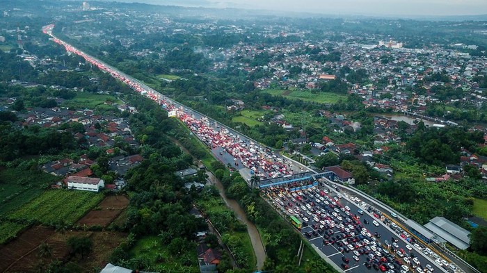 Foto udara ribuan kendaraan terjebak kemacetan di pintu keluar Tol Ciawi, Kabupaten Bogor, Jawa Barat, Minggu (23/4/2023). Kepadatan kendaraan tersebut terjadi imbas dari tingginya antusias warga yang akan berlibur menuju kawasan Puncak Bogor, sementara itu Polres Bogor memberlakukan arus lalu lintas satu arah dan sistem ganjil genap untuk mengurai kemacetan ke arah puncak. ANTARA FOTO/Raisan Al Farisi/nym.