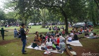 Tampak warga menggelar tikar untuk makan bersama di kawasan Ragunan.
