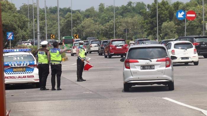 Polisi mengatur lalu lintas saat terjadi kepadatan di pintu keluar gerbang tol Jombang-Mojokerto (Jomo) Bandar Kedungmulyo, Kabupaten Jombang, Jawa Timur, Senin (24/4/2023). Penumpukan kendaraan di pintu keluar gerbang tol Jombang-Mojokerto di Bandar Kedungmulyo tersebut akibat kemacetan di jalan nasional Jombang-Kediri. ANTARA FOTO/Syaiful Arif/YU