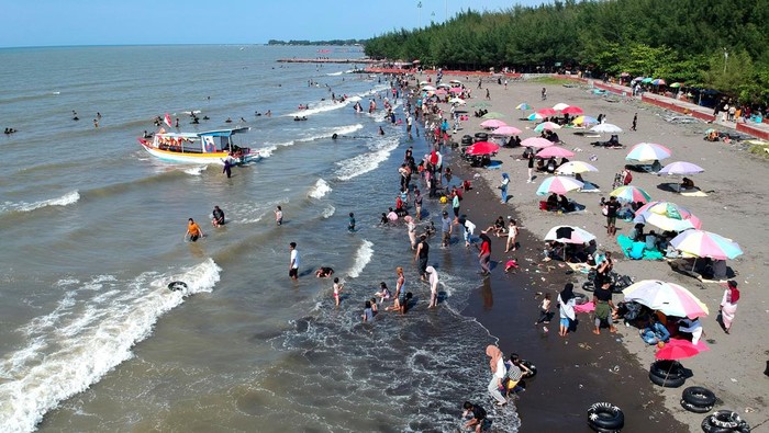 Wisatawan bermain air di pinggir Pantai Alam Indah, Tegal, Jawa Tengah, Minggu (23/4/2023). Wisata pantai utara menjadi salah satu destinasi wisata warga untuk menikmati libur Lebaran bersama keluarga. ANTARA FOTO/Oky Lukmansyah/rwa.