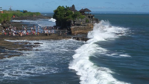 Wisatawan menikmati suasana pantai saat berkunjung di objek wisata Tanah Lot, Tabanan, Bali, Minggu (23/4/2023). Pengelola Daya Tarik Wisata (DTW) Tanah Lot mencatat jumlah kunjungan wisatawan saat hari libur Idul Fitri 1444 H pada Sabtu (22/4) sebanyak 9.202 orang, angka tersebut meningkat dibandingkan jumlah kunjungan pada hari-hari biasa yang rata-rata 2.000 orang. ANTARA FOTO/Nyoman Hendra Wibowo/nym.
