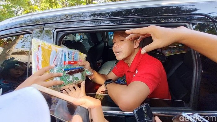 Gubernur Jawa Tengah Ganjar Pranowo membagikan buku ke pengunjung Solo Safari, Selasa (25/4/2023).