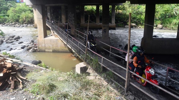 Sejumlah pengendara motor antre untuk menyeberangi jembatan Sungai Ciliwung, Katulampa, Kota Bogor, Jawa Barat, Selasa (25/4/2023). Jembatan tersebut menjadi jalan alternatif  bagi pengendara motor untuk menuju jalur wisata Puncak, Kabupaten Bogor saat kepadatan arus lalu lintas di jalan utama pada liburan Lebaran. ANTARA FOTO/Arif Firmansyah/rwa.
