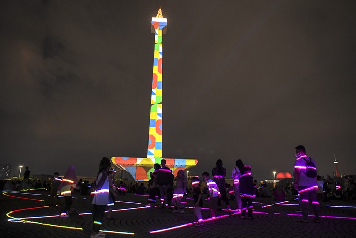 Pengunjung menyaksikan pertunjukan video mapping di Monumen Nasional (Monas), Jakarta, Senin (24/4/2023). Pemprov DKI mengadakan pagelaran Monas Week dan Pentas Seni Monas dengan menampilkan berbagai macam pertunjukan diantaranya air mancur menari, video mapping, dan penampilan musik sebagai bentuk hiburan masyarakat pada libur Lebaran. ANTARA FOTO/M Risyal Hidayat/aww.
