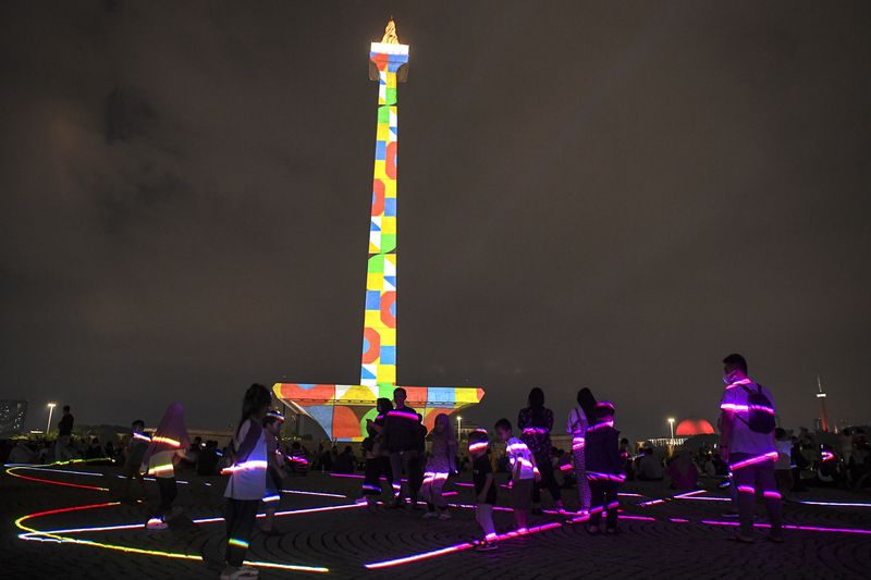 Pengunjung menyaksikan pertunjukan video mapping di Monumen Nasional (Monas), Jakarta, Senin (24/4/2023). Pemprov DKI mengadakan pagelaran Monas Week dan Pentas Seni Monas dengan menampilkan berbagai macam pertunjukan diantaranya air mancur menari, video mapping, dan penampilan musik sebagai bentuk hiburan masyarakat pada libur Lebaran. ANTARA FOTO/M Risyal Hidayat/aww.