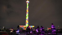 Pengunjung menyaksikan pertunjukan video mapping di Monumen Nasional (Monas), Jakarta, Senin (24/4/2023). 
